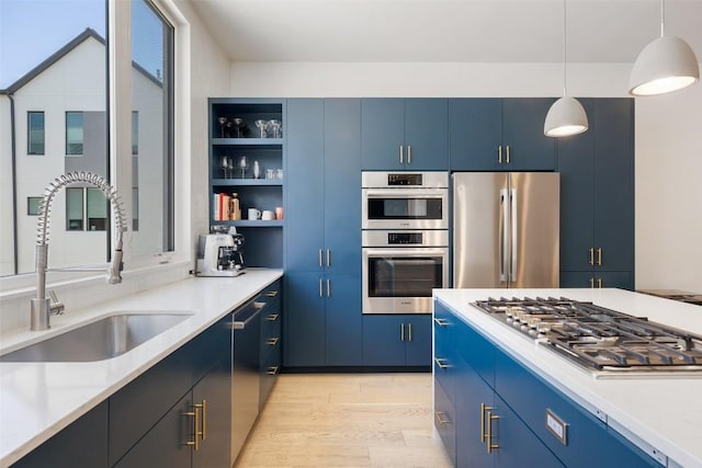 3100 Menchaca Rd Unit 24, Austin, TX 78704 - kitchen featuring stainless steel appliances, blue cabinetry, open shelves, and light wood-type flooring