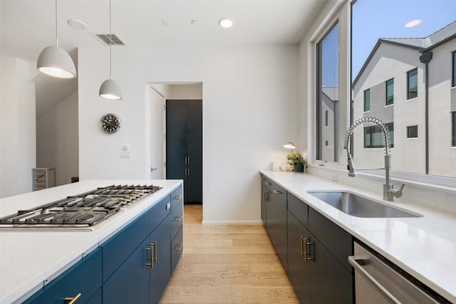 3100 Menchaca Rd Unit 24, Austin, TX 78704 - kitchen featuring stainless steel appliances, light wood-style flooring, blue cabinets, light countertops, and recessed lighting