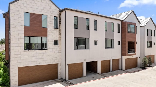 3100 Menchaca Rd Unit 24, Austin, TX 78704 - view of front of house with an attached garage, a standing seam roof, a metal roof, and driveway