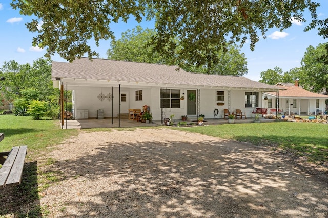 1215 Bois Darc St, Lockhart, TX 78644 - rear view of property featuring a lawn, a patio area, and driveway