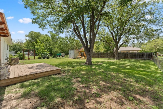 1215 Bois Darc St, Lockhart, TX 78644 - fenced backyard with a wooden deck and a playground