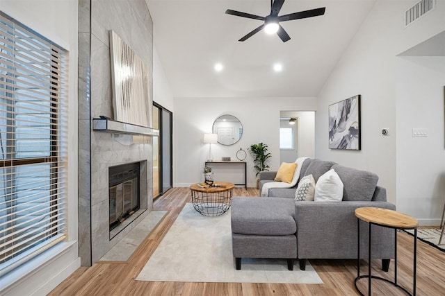 12307 Marogot Run, Austin, TX 78758 - living room with a ceiling fan, light wood finished floors, a fireplace, and high vaulted ceiling