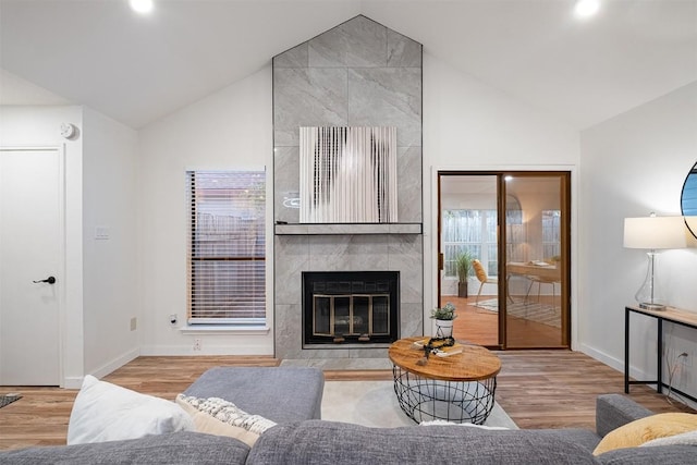 12307 Marogot Run, Austin, TX 78758 - living area featuring wood finished floors, a tiled fireplace, and high vaulted ceiling