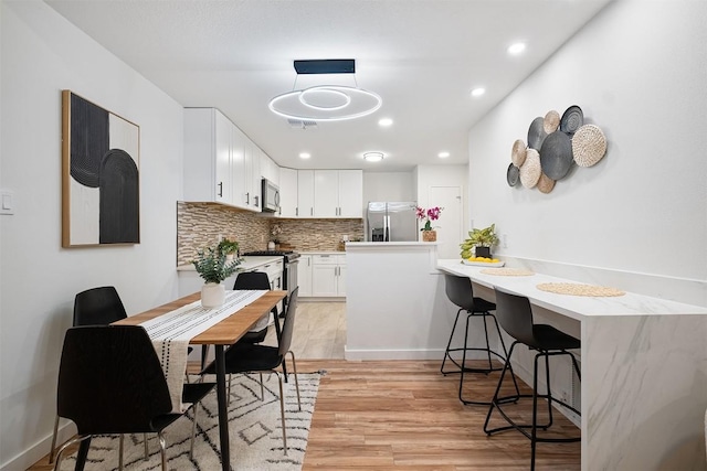 12307 Marogot Run, Austin, TX 78758 - dining room featuring light wood-style flooring and recessed lighting