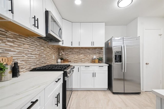 12307 Marogot Run, Austin, TX 78758 - kitchen with appliances with stainless steel finishes, white cabinetry, decorative backsplash, and light stone countertops