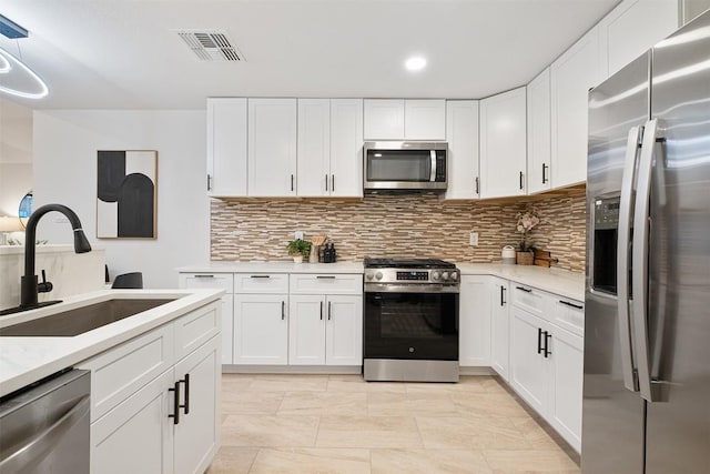 12307 Marogot Run, Austin, TX 78758 - kitchen with stainless steel appliances, light countertops, tasteful backsplash, white cabinets, and recessed lighting