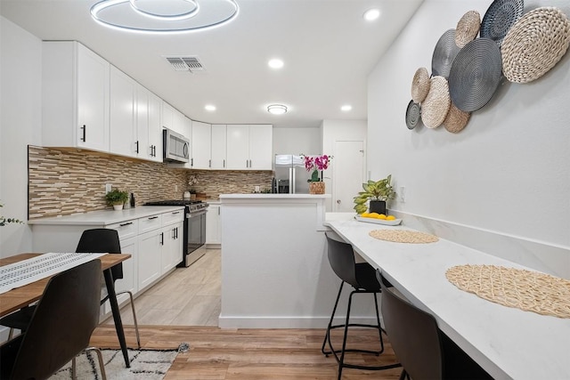 12307 Marogot Run, Austin, TX 78758 - kitchen with appliances with stainless steel finishes, decorative backsplash, white cabinetry, light countertops, and recessed lighting