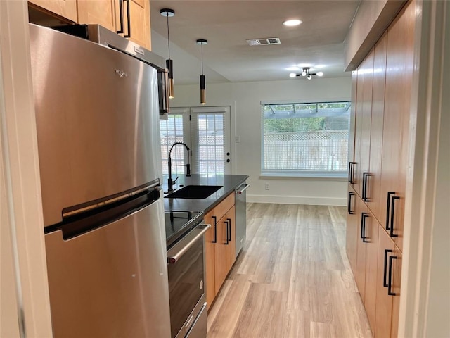 5809 Cherry Creek Dr, Austin, TX 78745 - kitchen featuring stainless steel appliances, dark countertops, light wood-style floors, recessed lighting, and light brown cabinetry