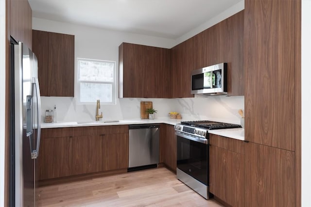 5304 Samuel Huston Ave Unit B, Austin, TX 78721 - kitchen with stainless steel appliances, modern cabinets, light countertops, light wood-type flooring, and backsplash