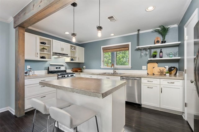 3207 Harpers Ferry Ln, Austin, TX 78745 - kitchen with open shelves, appliances with stainless steel finishes, under cabinet range hood, ornamental molding, and dark wood-type flooring