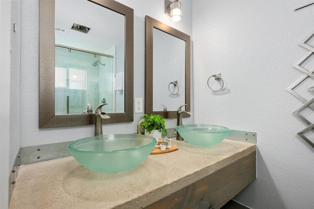 3207 Harpers Ferry Ln, Austin, TX 78745 - bathroom with double vanity, an enclosed shower, and a textured wall