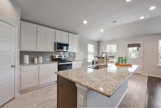 21510 Paine Ave, Lago Vista, TX 78645 - kitchen featuring appliances with stainless steel finishes, light wood-type flooring, vaulted ceiling, recessed lighting, and tasteful backsplash