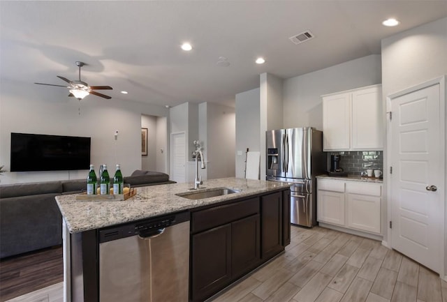 21510 Paine Ave, Lago Vista, TX 78645 - kitchen featuring stainless steel appliances, open floor plan, a kitchen island with sink, light stone counters, and recessed lighting