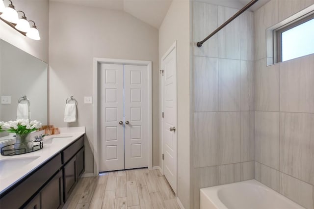21510 Paine Ave, Lago Vista, TX 78645 - full bath with double vanity, shower / bath combination, vaulted ceiling, and wood finished floors