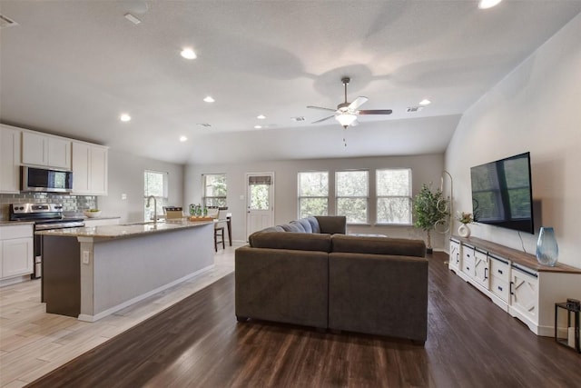 21510 Paine Ave, Lago Vista, TX 78645 - living room featuring vaulted ceiling, wood finished floors, ceiling fan, and recessed lighting