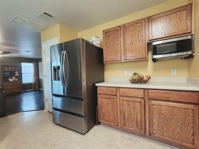 203 Pheasant Trl, Bastrop, TX 78602 - kitchen with appliances with stainless steel finishes, brown cabinetry, and light countertops