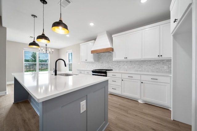 122 Buffalo Ridge Rd, Giddings, TX 78942 - kitchen with custom exhaust hood, decorative backsplash, light wood finished floors, light countertops, and recessed lighting