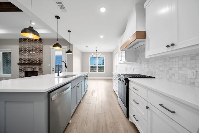 122 Buffalo Ridge Rd, Giddings, TX 78942 - kitchen with stainless steel appliances, custom exhaust hood, light wood finished floors, light countertops, and tasteful backsplash