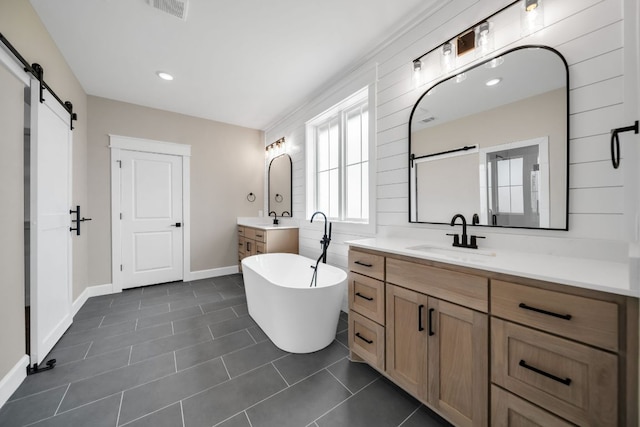 122 Buffalo Ridge Rd, Giddings, TX 78942 - bathroom featuring a freestanding bath, two vanities, recessed lighting, and tile patterned flooring