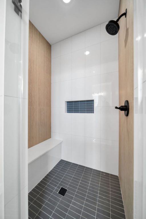 122 Buffalo Ridge Rd, Giddings, TX 78942 - full bathroom with tiled shower, tile walls, and tile patterned flooring