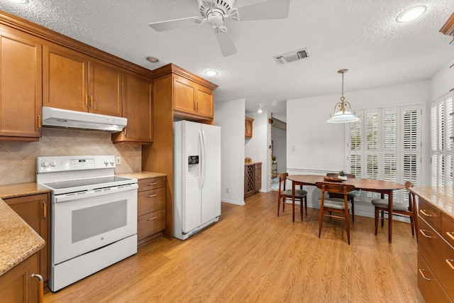 605 Flamingo Blvd, Lakeway, TX 78734 - kitchen featuring white appliances, under cabinet range hood, brown cabinets, a textured ceiling, and light wood-style flooring
