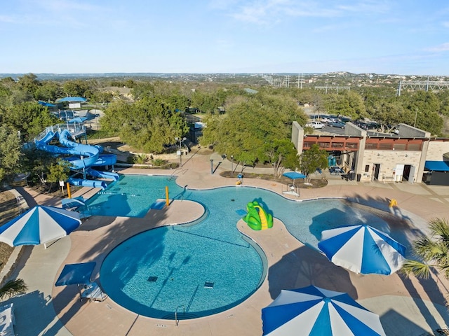 605 Flamingo Blvd, Lakeway, TX 78734 - community pool featuring a water slide, a water play area, a patio, and view of scattered trees