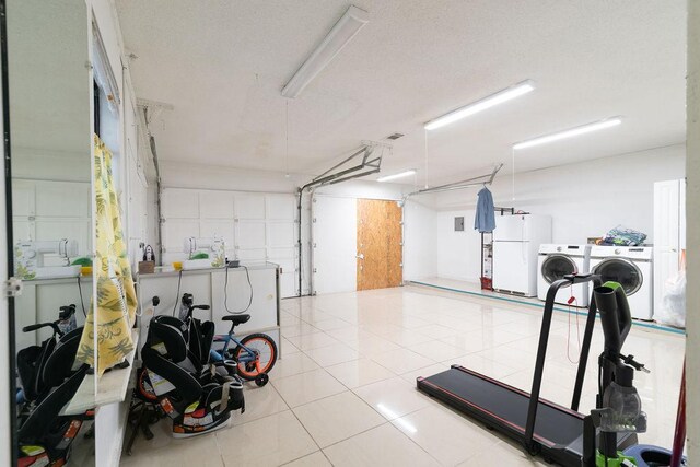 1106 Saucedo St, Austin, TX 78721 - exercise area featuring washing machine and clothes dryer, a garage, and tile patterned floors