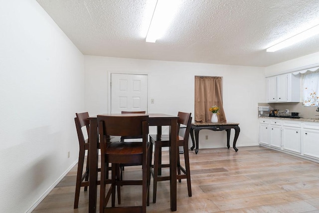 1106 Saucedo St, Austin, TX 78721 - dining area with a textured ceiling and light wood-style floors