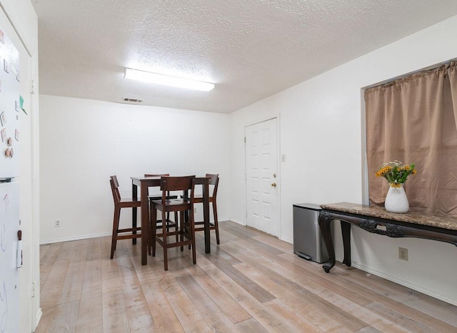 1106 Saucedo St, Austin, TX 78721 - dining room featuring light wood-style floors and a textured ceiling