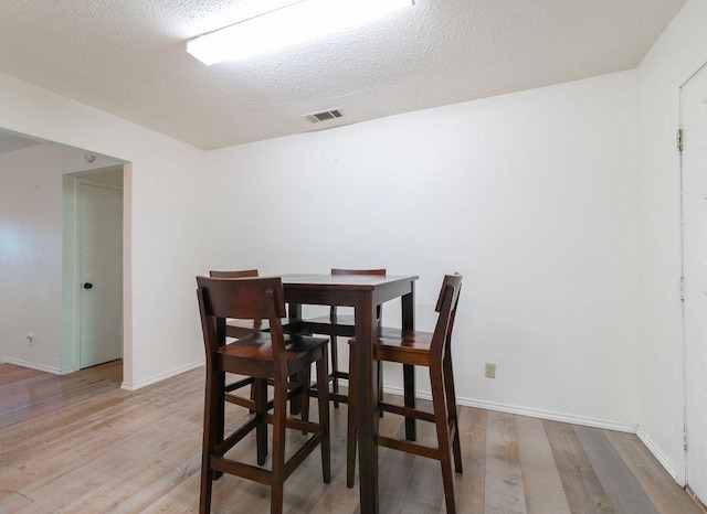 1106 Saucedo St, Austin, TX 78721 - dining area with light wood-style flooring and a textured ceiling
