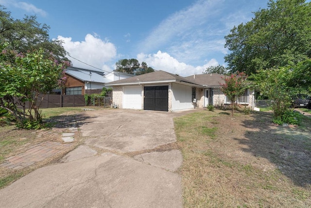 1106 Saucedo St, Austin, TX 78721 - ranch-style house featuring an attached garage and driveway
