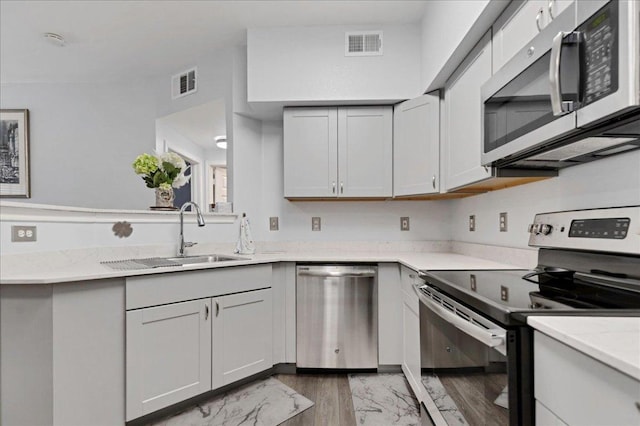 2320 Gracy Farms Ln Unit 918, Austin, TX 78758 - kitchen with stainless steel appliances, light stone countertops, light marble finish flooring, and a peninsula