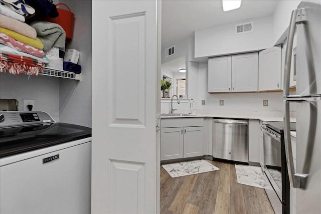 2320 Gracy Farms Ln Unit 918, Austin, TX 78758 - laundry room featuring washer / dryer and wood finished floors