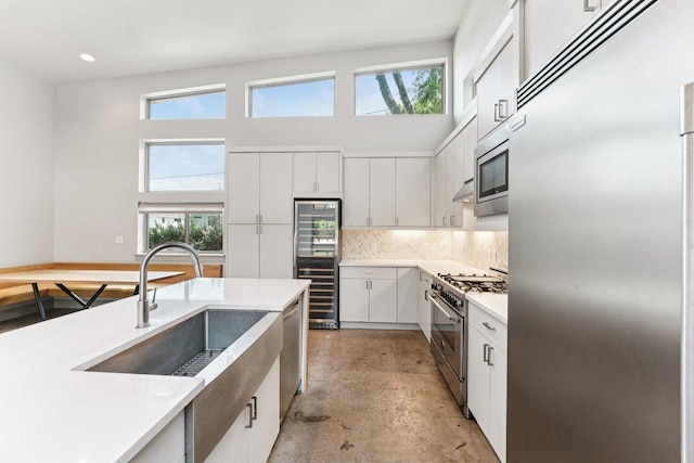 2004 Pennsylvania Ave Unit A, Austin, TX 78702 - kitchen featuring built in appliances, beverage cooler, concrete floors, healthy amount of natural light, and recessed lighting