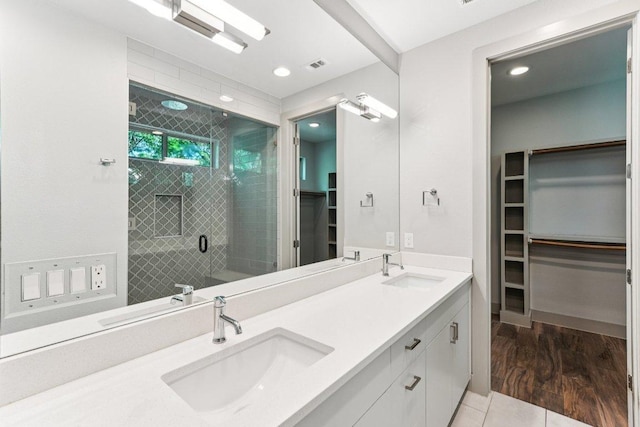 2004 Pennsylvania Ave Unit A, Austin, TX 78702 - bathroom with a spacious closet, double vanity, a shower stall, recessed lighting, and tile patterned flooring