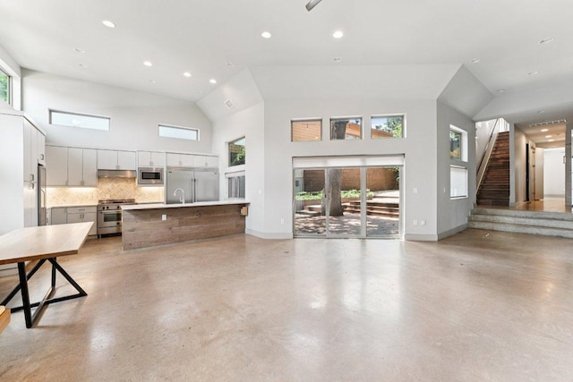 2004 Pennsylvania Ave Unit A, Austin, TX 78702 - unfurnished living room featuring high vaulted ceiling, concrete flooring, stairway, and recessed lighting