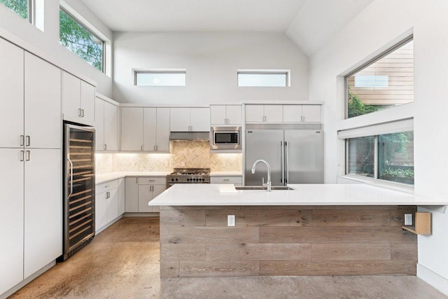2004 Pennsylvania Ave Unit A, Austin, TX 78702 - kitchen featuring built in appliances, beverage cooler, high vaulted ceiling, finished concrete floors, and tasteful backsplash