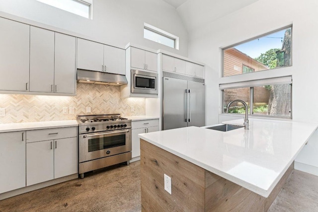 2004 Pennsylvania Ave Unit A, Austin, TX 78702 - kitchen with built in appliances, under cabinet range hood, high vaulted ceiling, decorative backsplash, and light countertops