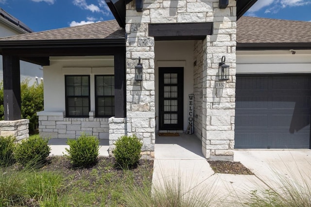 1332 Brescia Walk, Leander, TX 78641 - view of exterior entry featuring stone siding, roof with shingles, a garage, and driveway