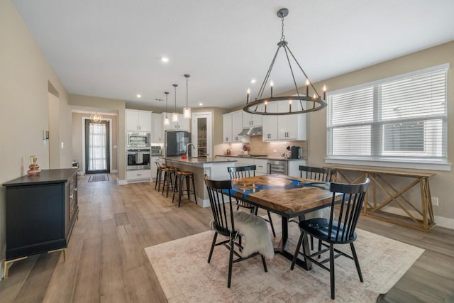 1332 Brescia Walk, Leander, TX 78641 - dining area featuring a chandelier, light wood-type flooring, and recessed lighting