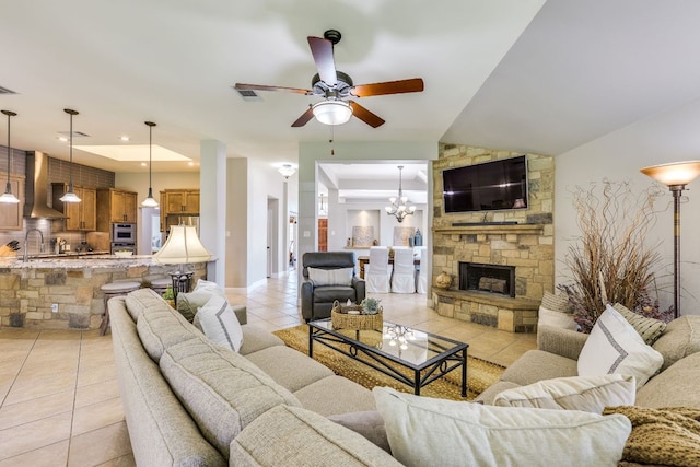 604 Cutty Trl, Lakeway, TX 78734 - living area featuring light tile patterned floors, a ceiling fan, a fireplace, and a chandelier