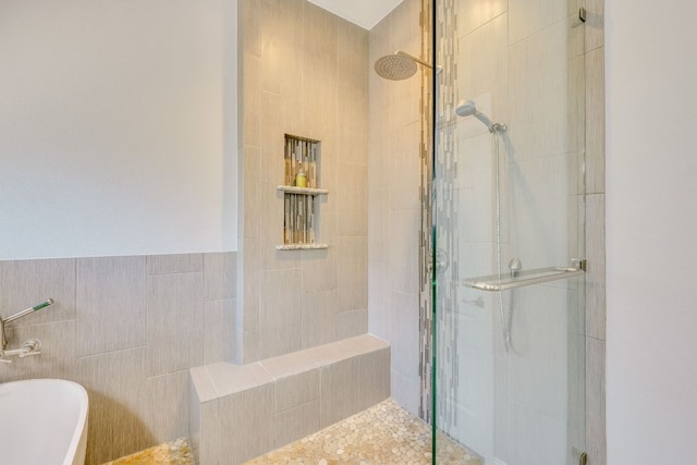 604 Cutty Trl, Lakeway, TX 78734 - bathroom featuring a stall shower, tile walls, and a freestanding tub
