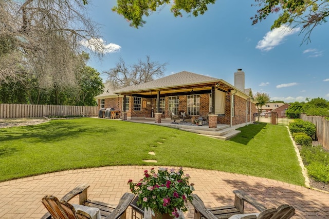 604 Cutty Trl, Lakeway, TX 78734 - rear view of house featuring a chimney, a patio, a fenced backyard, and brick siding