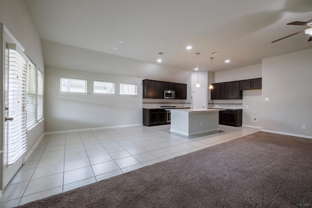 21016 Abigail Way, Pflugerville, TX 78660 - kitchen with stainless steel microwave, open floor plan, light tile patterned flooring, light countertops, and recessed lighting