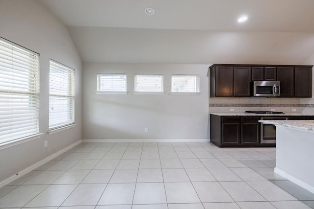 21016 Abigail Way, Pflugerville, TX 78660 - kitchen with stainless steel appliances, lofted ceiling, dark brown cabinets, backsplash, and light tile patterned floors