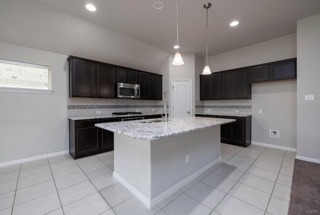 21016 Abigail Way, Pflugerville, TX 78660 - kitchen with appliances with stainless steel finishes, tasteful backsplash, light tile patterned flooring, light stone countertops, and an island with sink