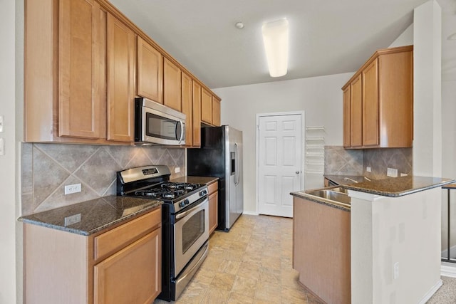 1310 Parmer Ln W Unit 3201, Austin, TX 78727 - kitchen featuring appliances with stainless steel finishes, a peninsula, decorative backsplash, and dark stone countertops