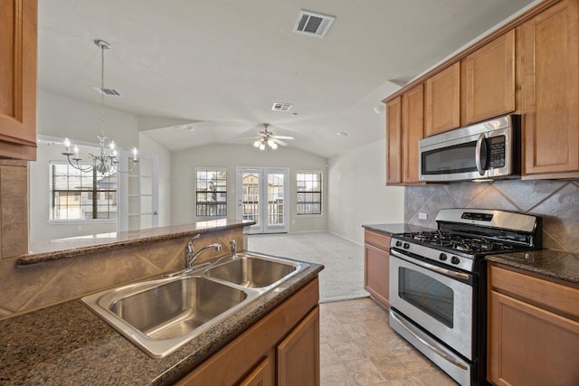 1310 Parmer Ln W Unit 3201, Austin, TX 78727 - kitchen with appliances with stainless steel finishes, brown cabinets, a chandelier, decorative light fixtures, and lofted ceiling