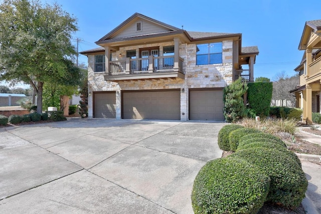 1310 Parmer Ln W Unit 3201, Austin, TX 78727 - view of front of property featuring stone siding, concrete driveway, a garage, and a balcony