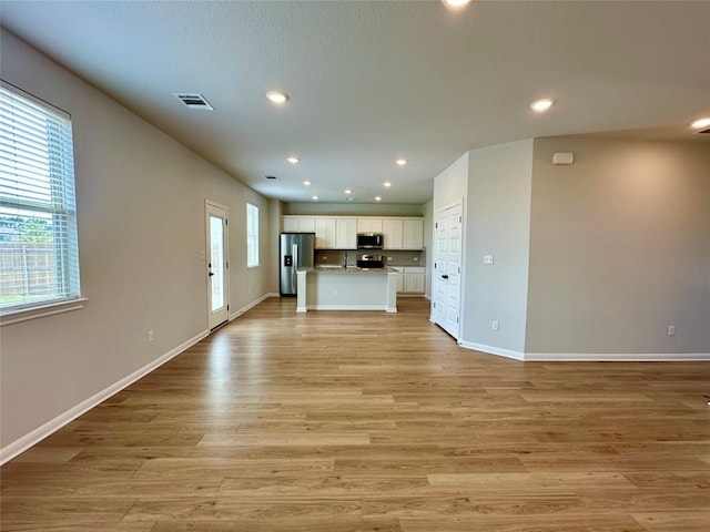 149 Gullivers Dr, Elgin, TX 78621 - unfurnished living room with light wood finished floors and recessed lighting